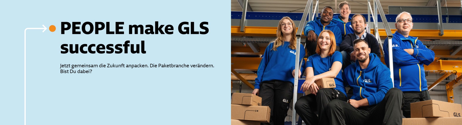 Mehrere Mitarbeitende sitzen lächelnd auf einer Treppe im Depot