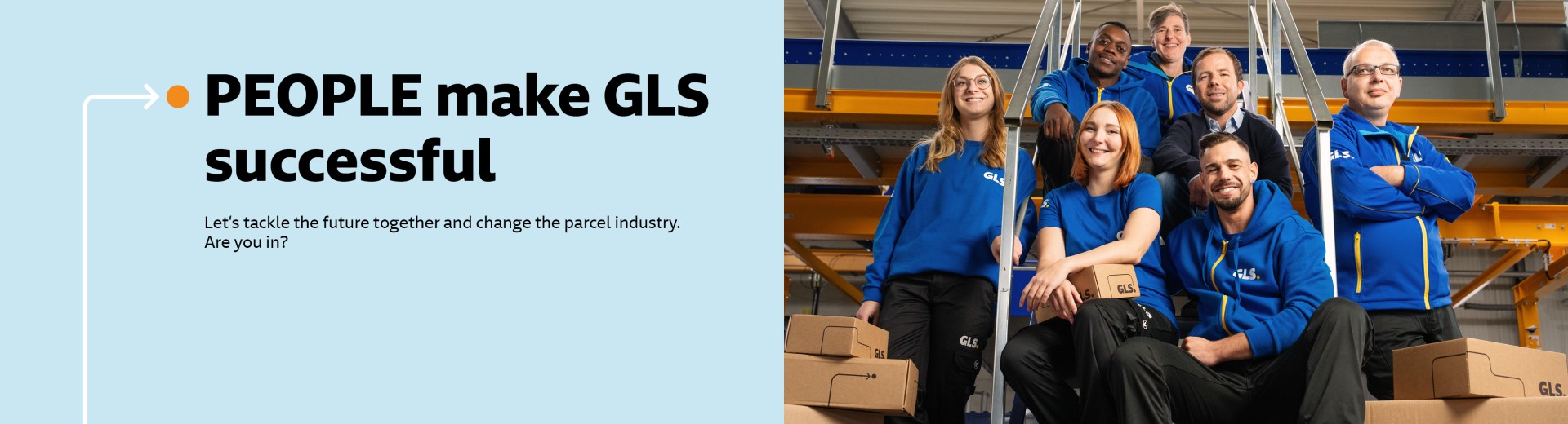 Several employees sit smiling on a staircase in the depot