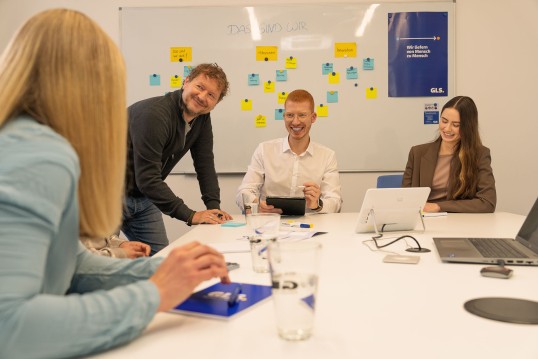 Employees in a meeting at the office talking an laughing with each other