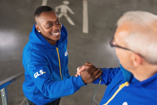 Two employees in the depot shake hands