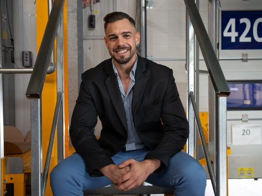 Manager in the Depot sitting on the stairs and smiling at the camera
