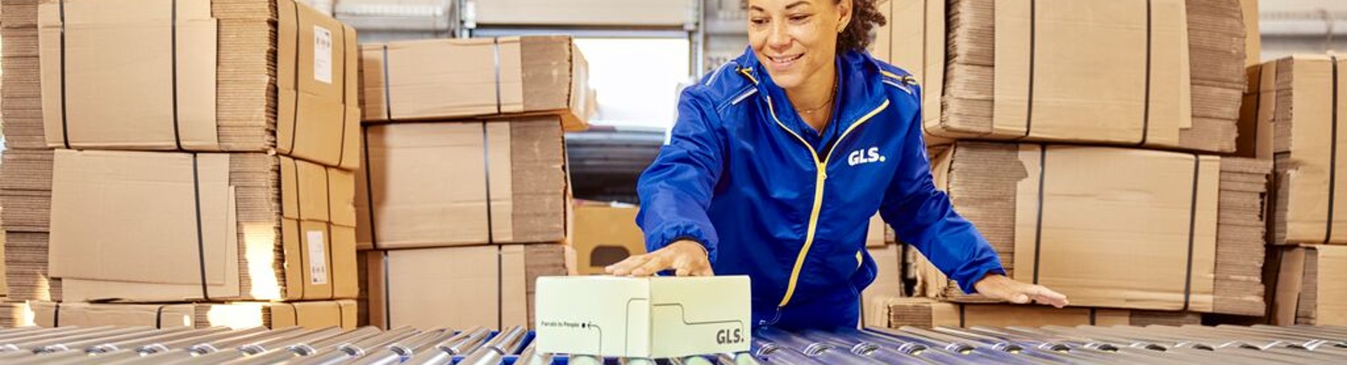 Employee with a parcel at the conveyor belt