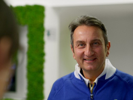 GLS Mitarbeiter steht im Paketshop und lächelt in die Kamera